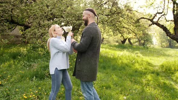 The Man Is Giving His Girlfriend a Bunch of Dandelions