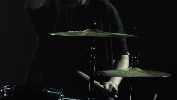 Drummer Playing on Drum Kit on Stage in a Dark Studio with Smoke and Neon Lighting. Dynamic Neon