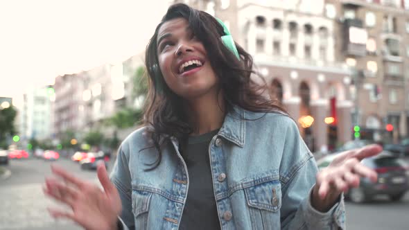 Happy Funky Cool African American Woman Wearing Headphones Dancing on Street