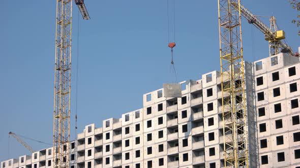 Yellow Crane Lifts Up Concrete Floor on the Building