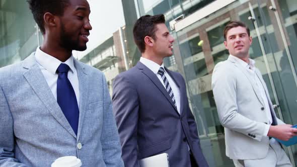 Business people interacting with each other while walking