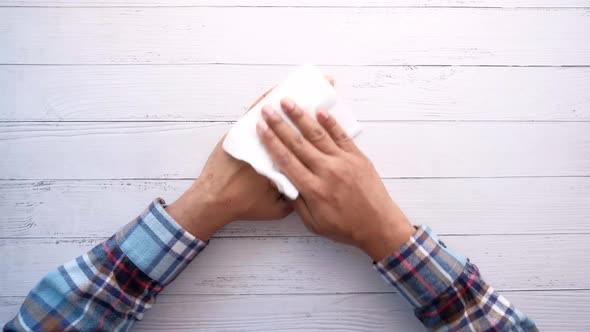 Man Disinfecting His Hands with a Wet Wipe