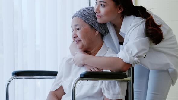 The daughter encourages and comforts a mother with cancer during hospitalization.