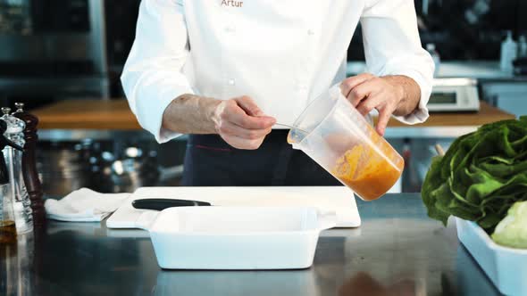 Professional restaurant kitchen, close-up: The chef creates sauce for meat