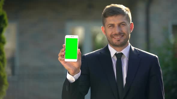 Estate Agent Holding Smartphone With Green Screen