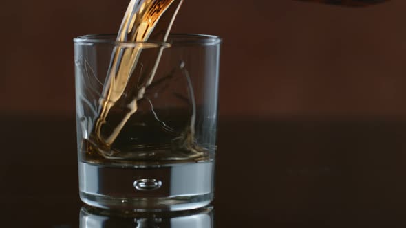 Whisky is poured into glass in slow motion; shot on Phantom Flex 4K at 1000 fps alt