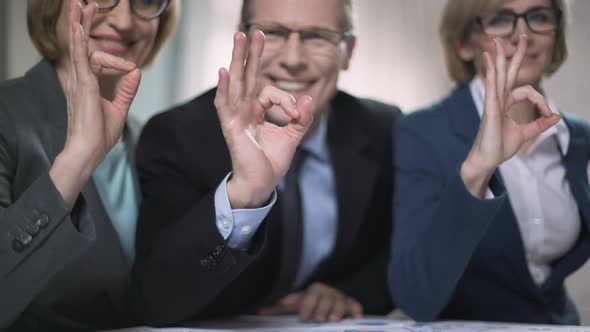 Smiling Colleagues Promise Excellent Service, Professionals Showing Ok Sign