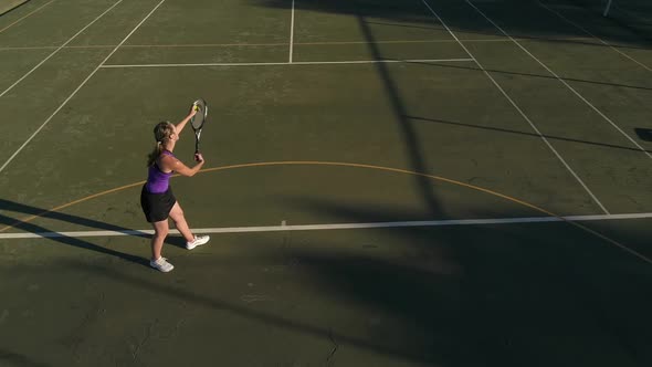 Aerial footage of a female tennis player playing tennis on a tennis court