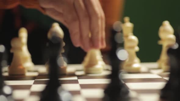 Chess board with a hand moving the white pawn