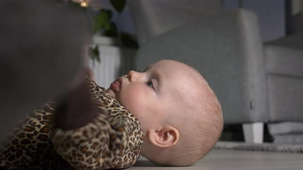 Young blue eyed baby girl on floor, close shot.