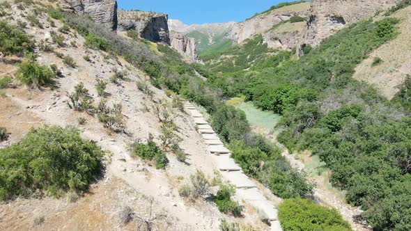 Flying above a trail leading into a rugged canyon in a wilderness area