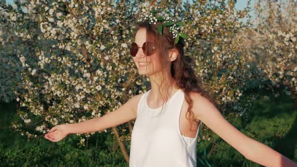 Beauty young woman enjoying nature in spring apple orchard, Happy Beautiful girl in Garden with bloo