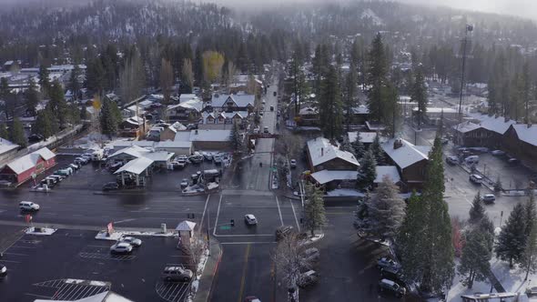 Aerial over snow covered buildings in town center of Big Bear during winter, Drone Christmas town