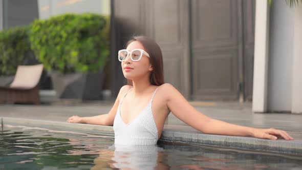 Young asian woman enjoy around outdoor swimming pool for leisure