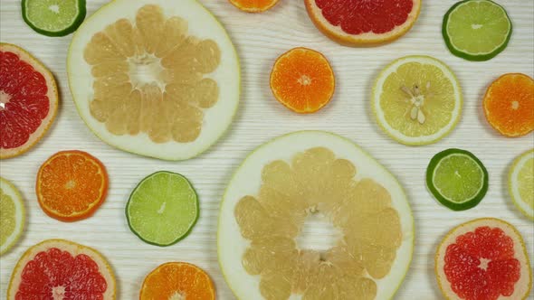 Slices Citrus Fruits Rotating Over Light Wooden Background. Stop Motion 