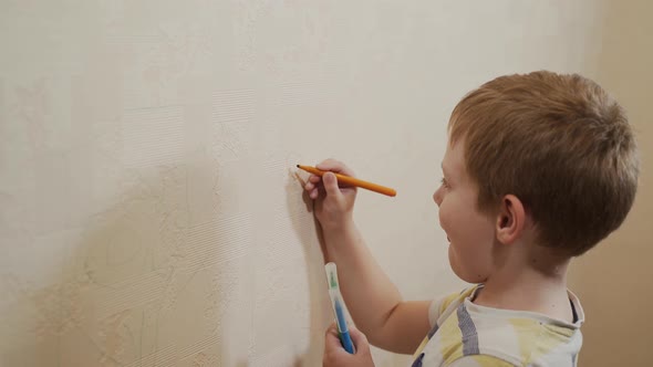 Caucasian Boy Selects a Marker Felttip Pen and Draws Them on the Wallpaper