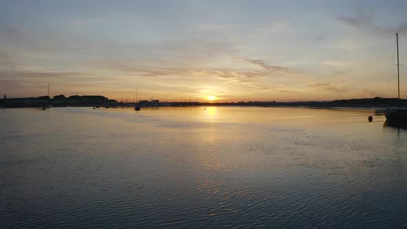 Beautiful sunset at The Malahide Marina. The drone is flying towards the sun and low to the water