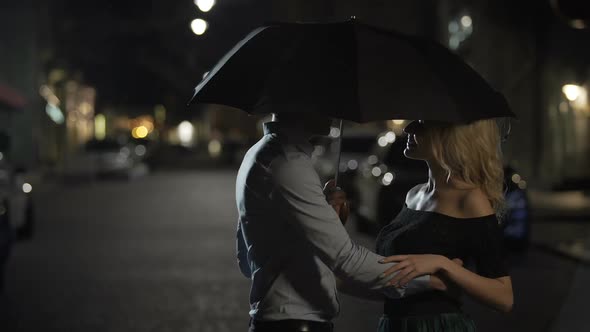 Beautiful Couple of Lovers Embracing Under Umbrella Night Date Love Story