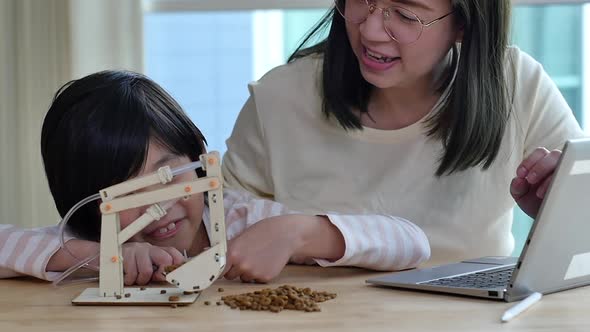 Asian Child Playing Diy Excavator Crane With His Mother