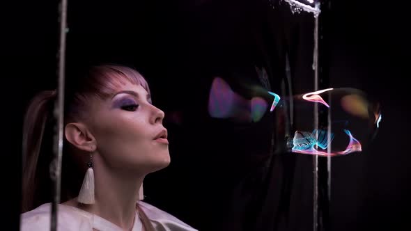 Close-up: Pretty Girl Does Tricks with Soap Bubbles. She Blows a Bubble Through Soap Curtain