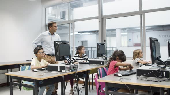 Computer Science Teacher Watching As Pupils Doing Task