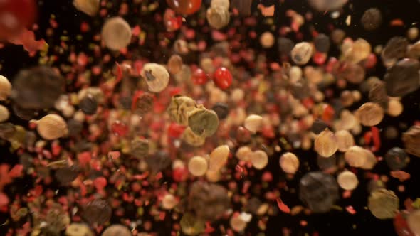 Super Slow Motion Detail Shot of Crushed Color Pepper Falling Down on Black Background at 1000Fps