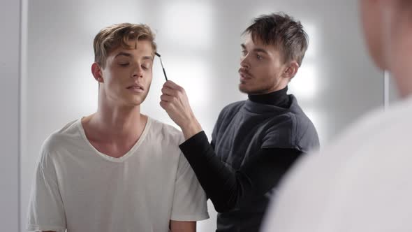 Male Makeup Model Making Selfie with Visagiste