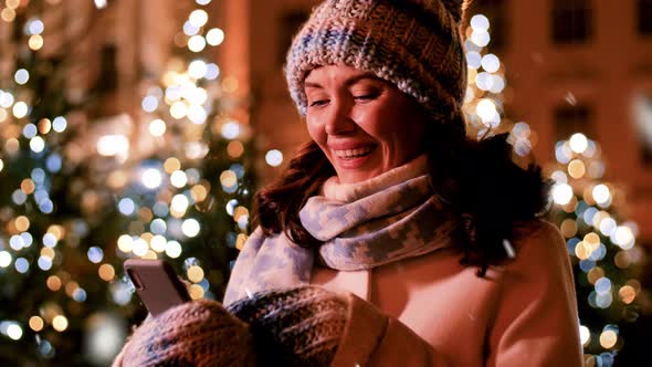 Happy Woman with Smartphone in Christmas City