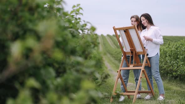 Elegant and Beautiful Girls Painting in a Field