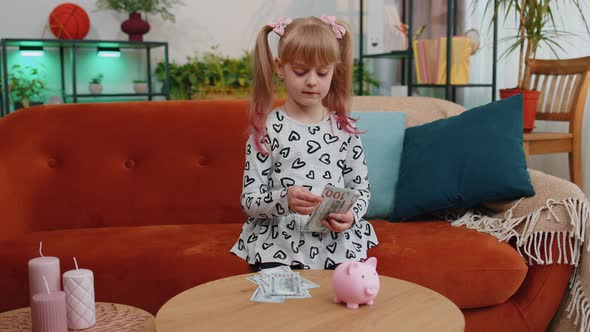 Little Toddler Kid Girl Counting Money Dollar Banknotes for Future Needs at Home Desk with Piggybank