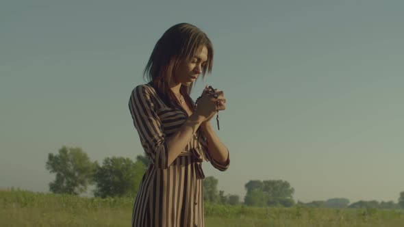 Christian Pretty African American Woman with Crucifix Saying Prayers Outdoors