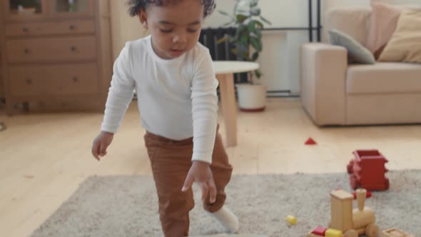 Cute Toddler Boy Putting Toys Away