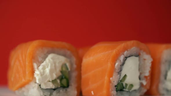 Close-up Sushi spins on a bright orange background. Set of Japanese sushi rolls Philadelphia