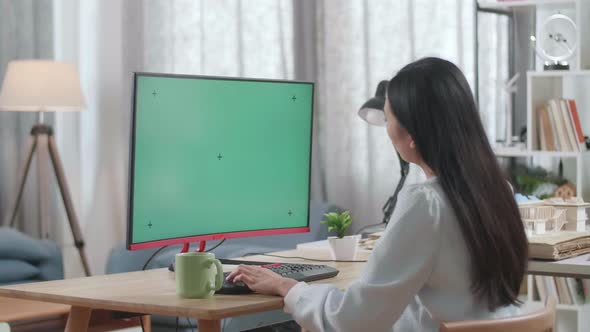 Asian Woman Engineer With The House Model Working On A Mock Up Green Screen Desktop At Home