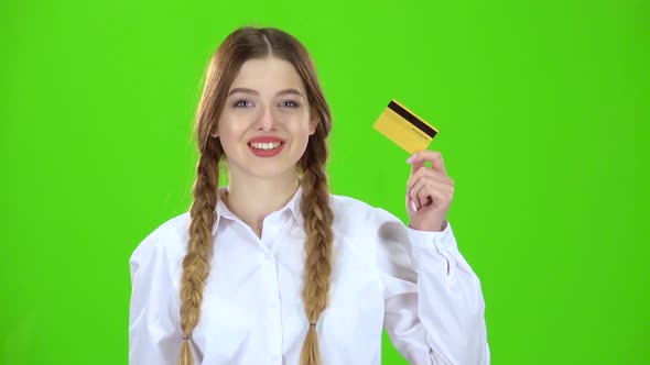 Student in a White Blouse with a Credit Card Is Happy. Green Screen