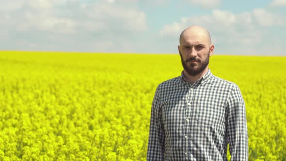Agronomist Examining Blossoming Canola Field