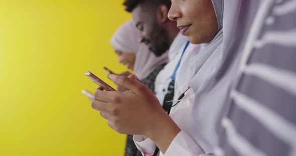 African Students Group Using Smart Phones Over Yellow Background