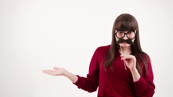 Caucasian Brunette Woman with Bangs Wearing Red Sweater Holding Paper Glasses with Mustache Disguise