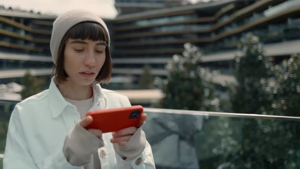 Woman Standing Near Shopping Watching Video on Smartphone