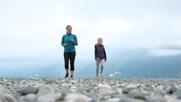 Little Girl with Mother Exercising on the Beach