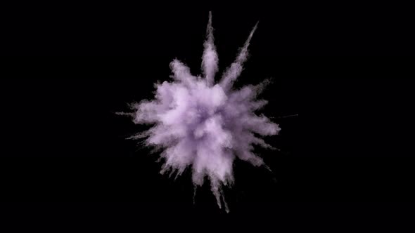 Colorful powder/particles fly after being exploded against black background. Slow Motion.