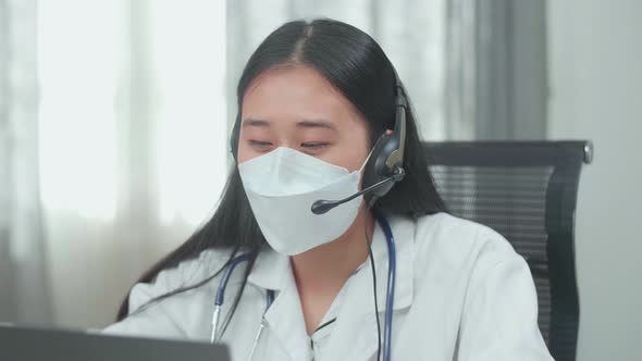 Close Up Asian Woman Doctor Wearing Headsets And Masks Working As Call Centre Agent