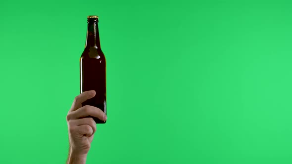 The Male Hand Points with the Index Finger to the Other Hand Holding a Bottle of Beer or Lemonade