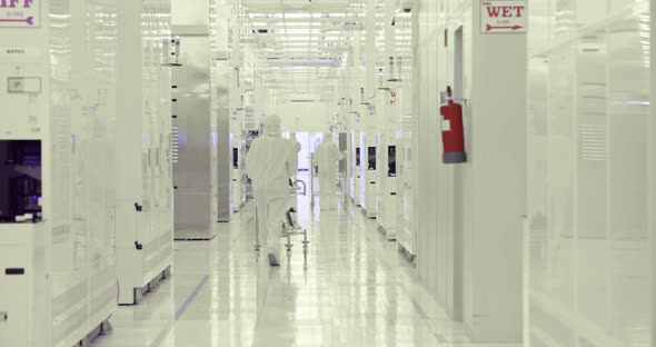 Workers in clean suits in a Semiconductor manufacturing facility