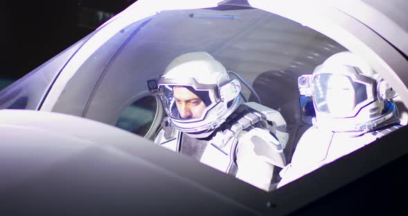 Male and Female Astronauts Navigating Spaceship