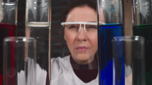Squinting Female Researcher Drips Catalyzer Into Test Tube