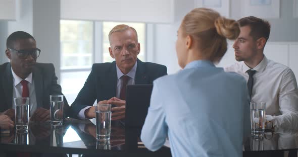 Group of Diverse Business People Working and Communicating While Sitting at Office Desk Together