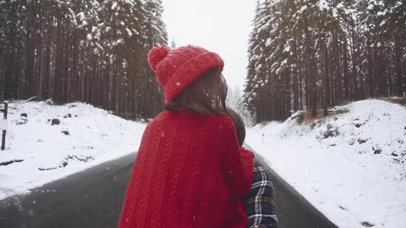 Young Couple in Love Kiss in First Snowy Winter Day in Forest Outdoors. Man and Woman on Date