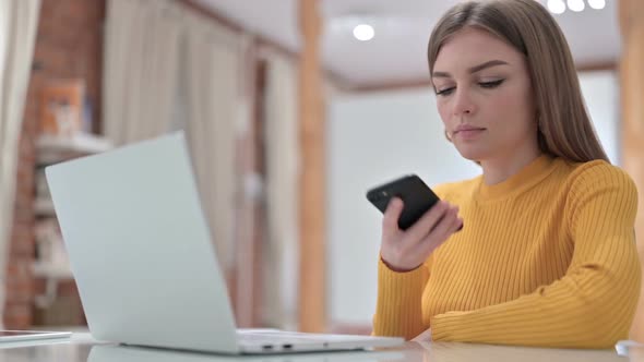 Young Female Doctor Talking on Smartphone in Office