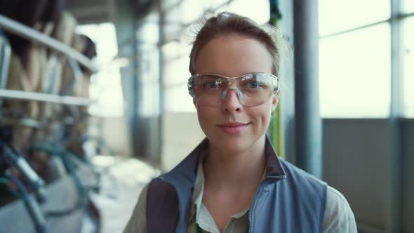 Closeup Dairy Farm Worker in Protective Glasses Posing at Milking Parlour Alone